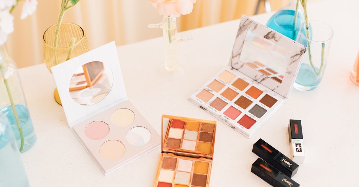 Aesthetic display of makeup palettes and lipsticks surrounded by flowers.